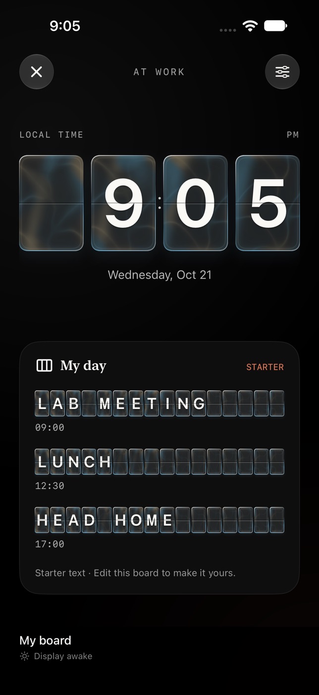 The At work display in portrait. A glass-finish split-flap clock reads 9:05 above a board titled My day, with three lines of tiles: Lab meeting, Lunch and Head home, marked as starter text.